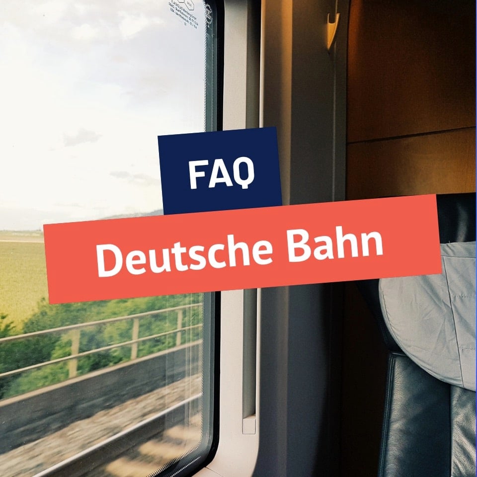 Blick aus dem Fenster eines fahrenden Zuges mit dem Schriftzug FAQ Deutsche Bahn