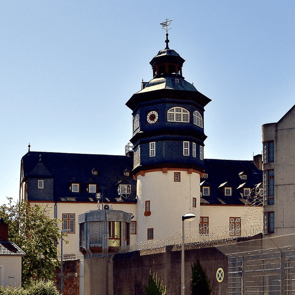 Historisches Gebäude einer Justizvollzugsanstalt mit Turm und Sicherheitszaun