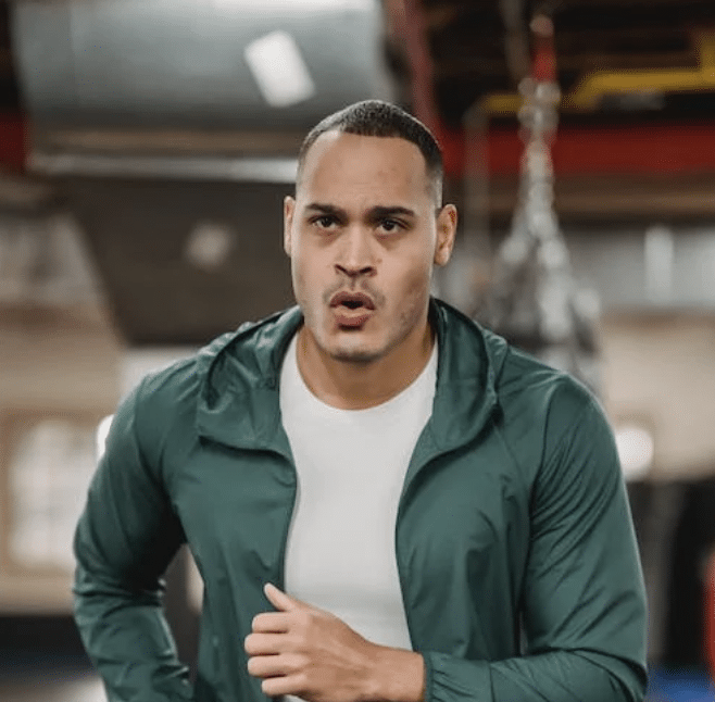 Fokussierter Mann beim Lauftraining für den Zoll-Sporttest in einer Sporthalle