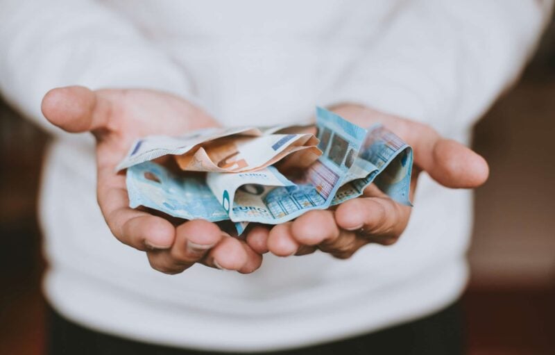 Zwei geöffnete Hände, die Euro-Geldscheine halten, passend zum Thema Gehalt beim BKA