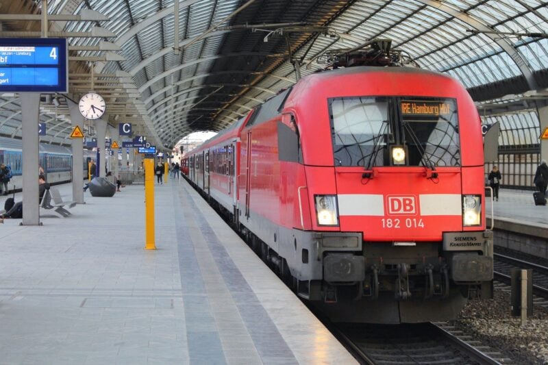 Ein roter Zug der Deutschen Bahn am Bahnsteig in einer Bahnhofshalle