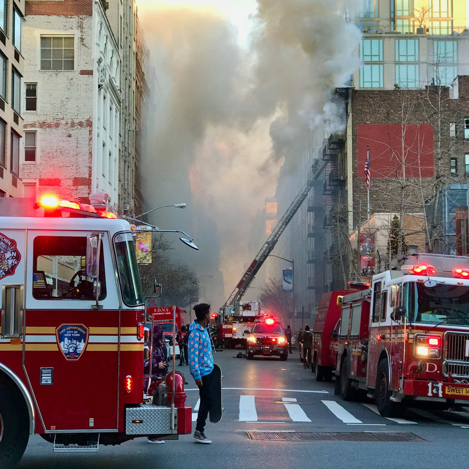 Feuerwehrfahrzeuge bei einem Einsatz mit starker Rauchentwicklung in einer Stadtstraße