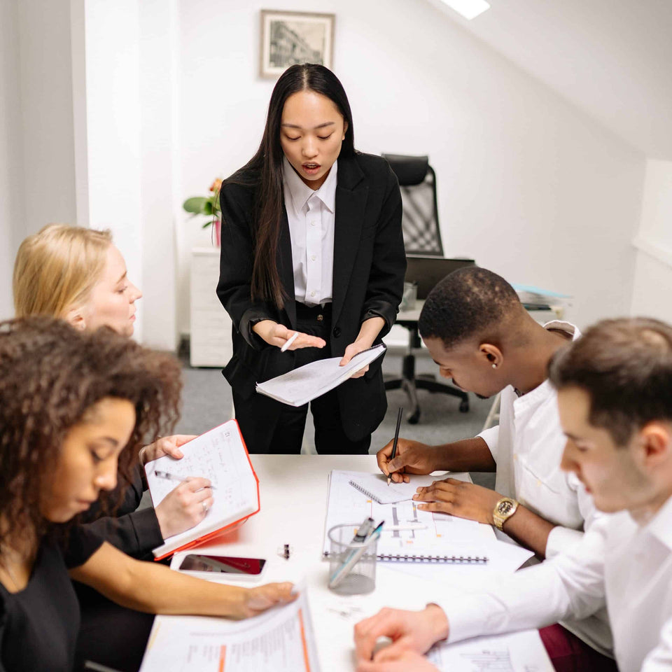 Eine Führungskraft im Gespräch mit ihrem Team bei einer Besprechung im Büro