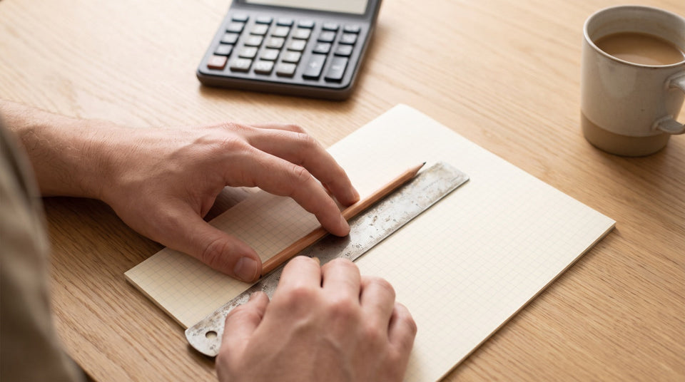 Hände lösen mit Bleistift und Taschenrechner Matheaufgaben zur Vorbereitung auf einen Aufnahmetest