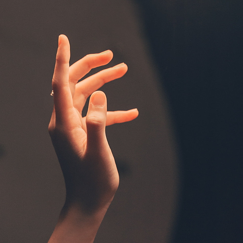 Eine geöffnete menschliche Hand im sanften Licht als Symbol für Physiotherapie und manuelle Arbeit