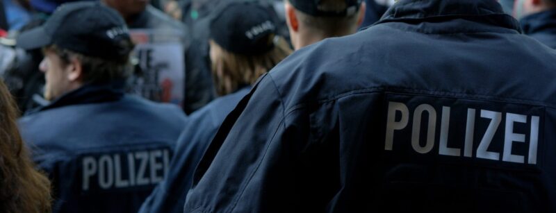 Polizisten in dunkelblauer Uniform mit dem Schriftzug Polizei auf dem Rücken