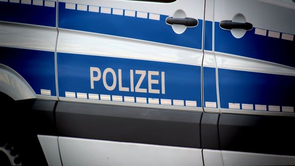 Nahaufnahme der blauen Seitenstreifen mit dem Schriftzug Polizei auf einem Einsatzfahrzeug