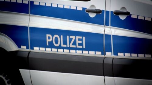 Nahaufnahme der blauen Aufschrift Polizei auf der Seite eines Polizeifahrzeugs