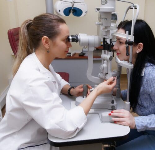 Eine Augenärztin untersucht die Augen einer Patientin mit einer Spaltlampe