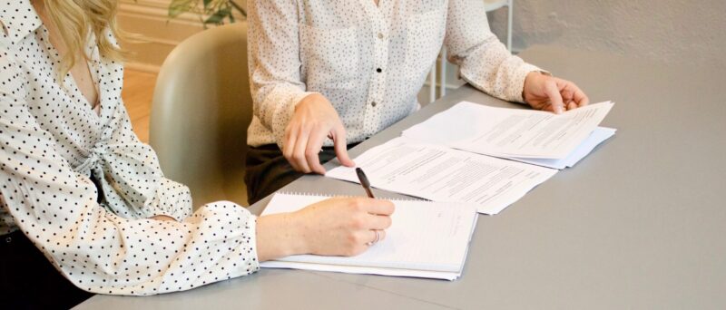 Zwei Personen besprechen Dokumente bei einem Bewerbungsgespräch für ein Stellenangebot
