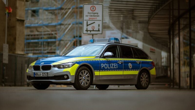 Ein blau-silberner Streifenwagen der Polizei mit Blaulicht auf einer Straße